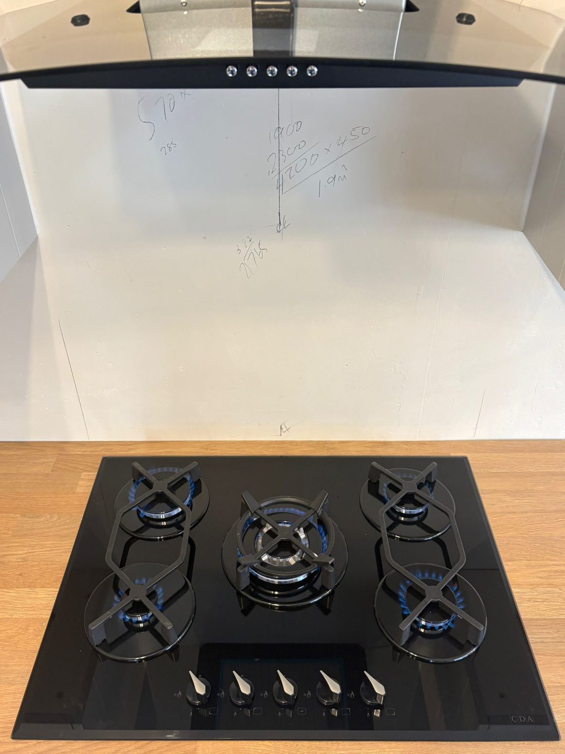 A black gas hob fitted into a wooden worktop