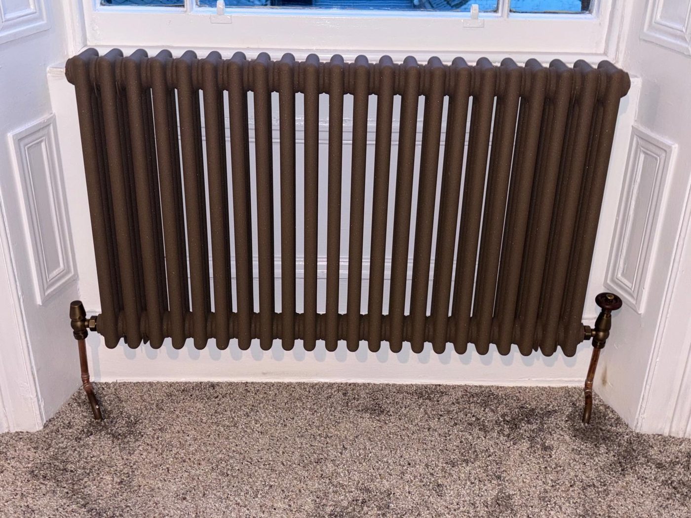 A cast-iron style column radiator under a bay window